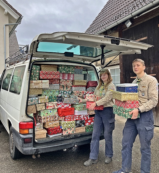 Eine große Zahl an schönen Weihnachtsgeschenken haben unsere Helden gepackt Zwei Pfadfinder laden die fertigen Päckchen ein